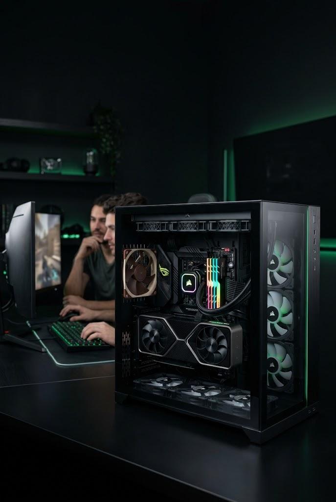 Torre gaming a medida SoloGaming con panel lateral de cristal e iluminación interior verde, montada junto al puesto de juego del cliente